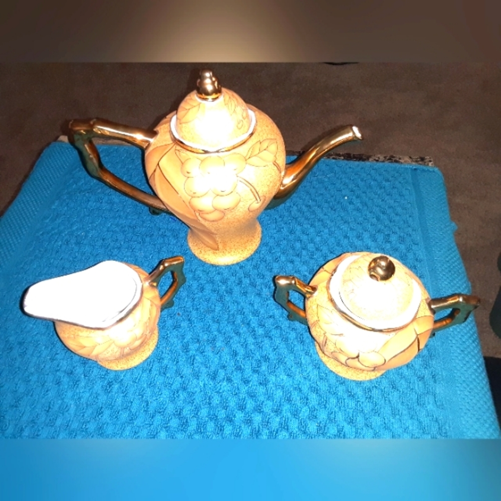 Orchid teapot set with gold trim.on all 3 pieces